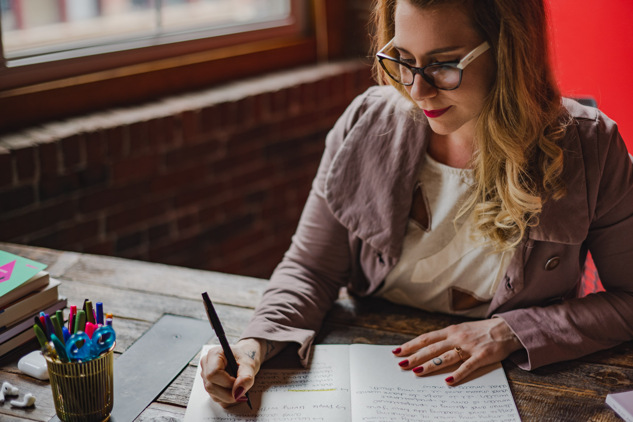 wooden table with coffee cup and open notebook with pencil