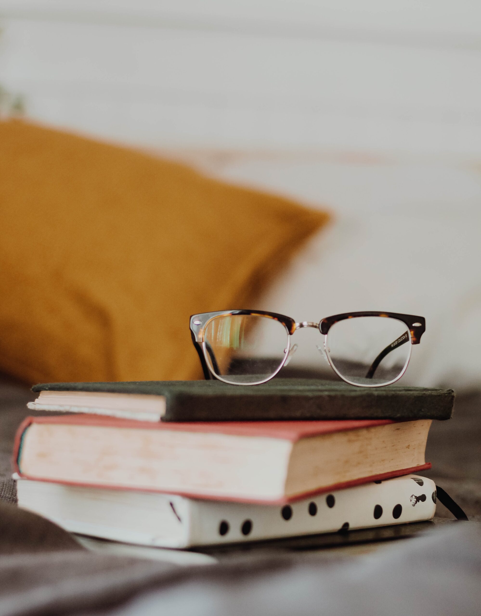 Stack of books with glasses resting on top